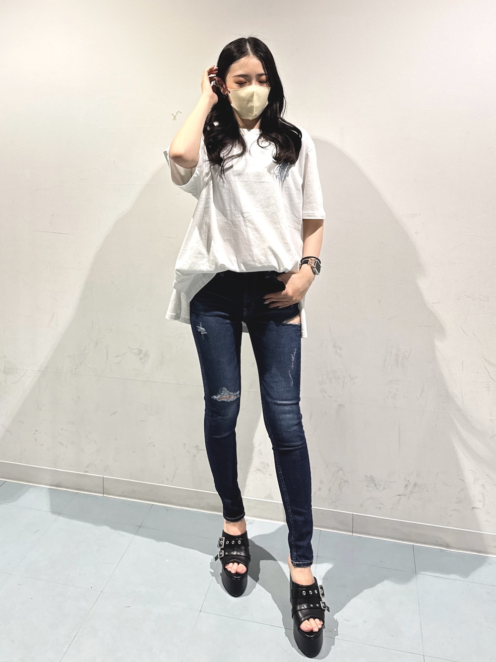 ホワイト系のTシャツ/カットソー、ブラック系のサンダル、ブルー系のデニムパンツを着用したレディースの夏コーディネートの1枚目の写真