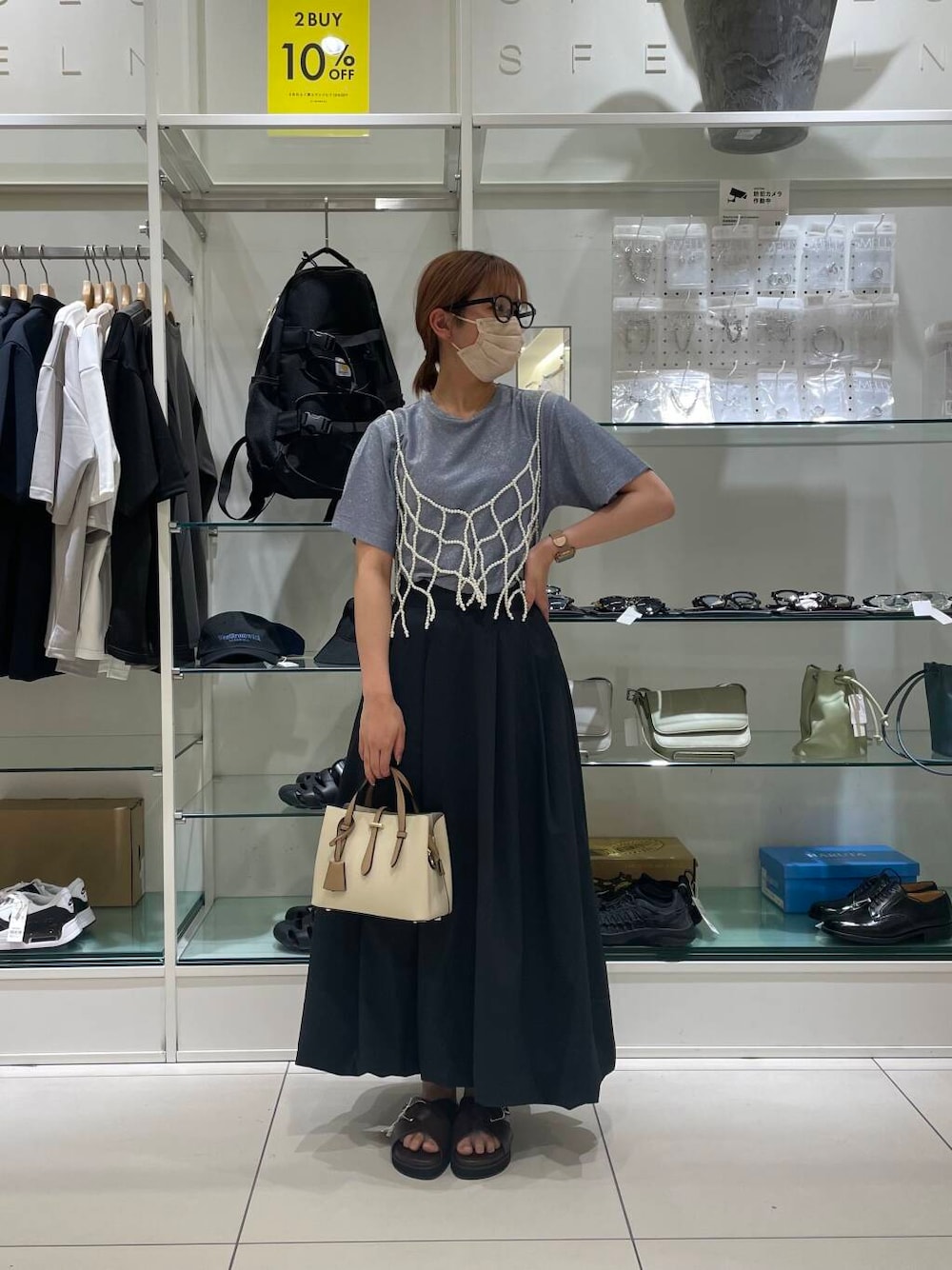 ホワイト系のハンドバッグ、ブラウン系のサンダル、ブルー系のTシャツ/カットソーを着用したレディースの夏コーディネートの1枚目の写真