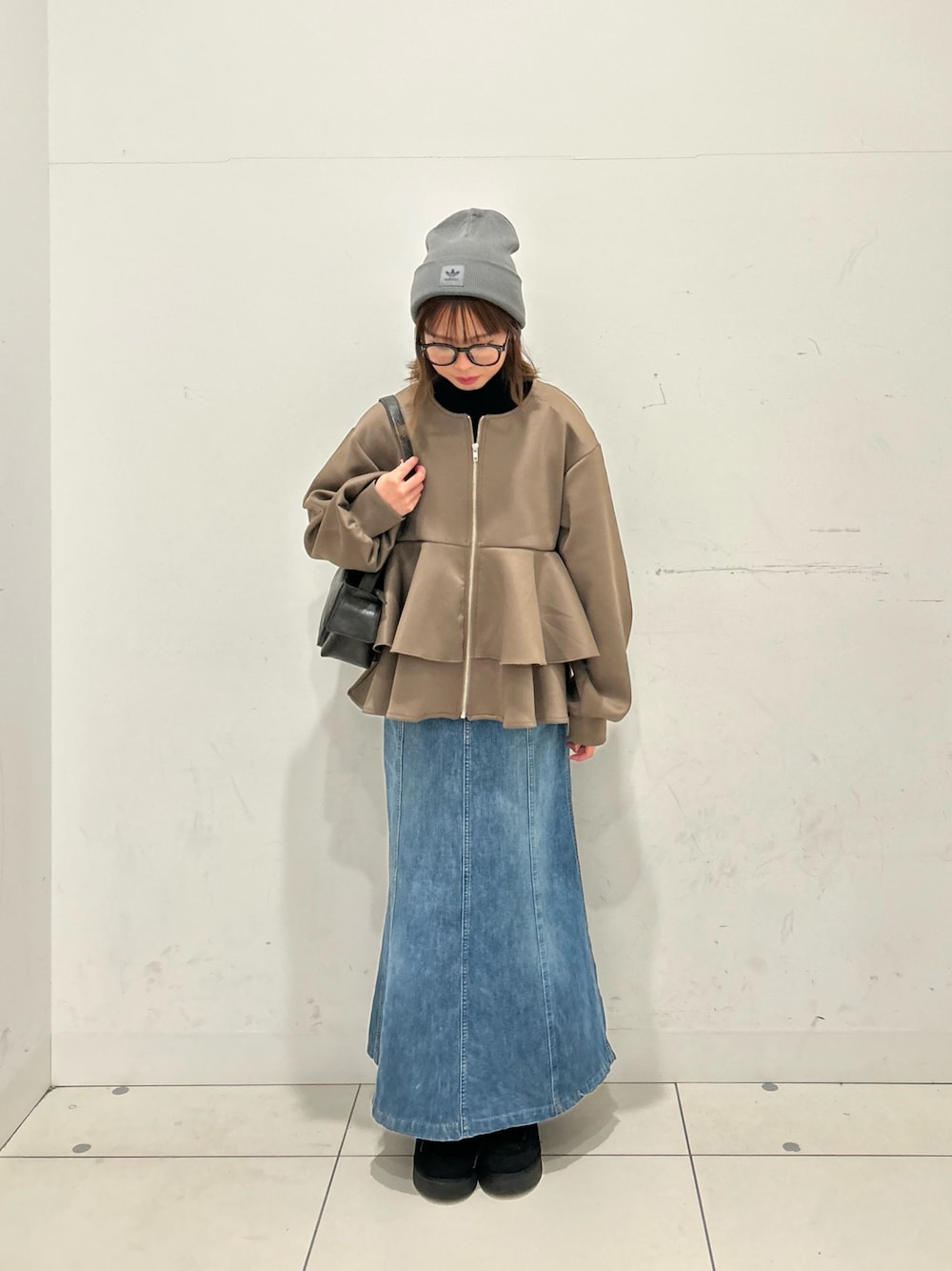 ブラウン系のカーディガン/ボレロ、ブラック系のニット/セーター、ブラック系のハンドバッグを着用したレディースの冬コーディネートの1枚目の写真