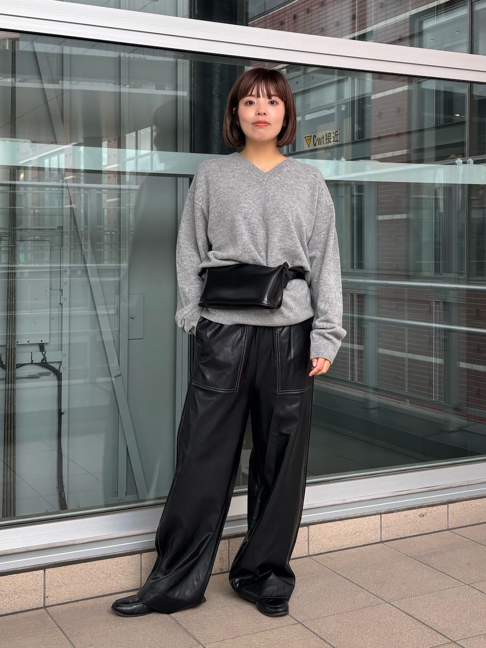 ブラック系のその他パンツ、ブラック系のボディバッグ/ウエストポーチ、グレー系のニット/セーターを着用したレディースの秋コーディネートの1枚目の写真