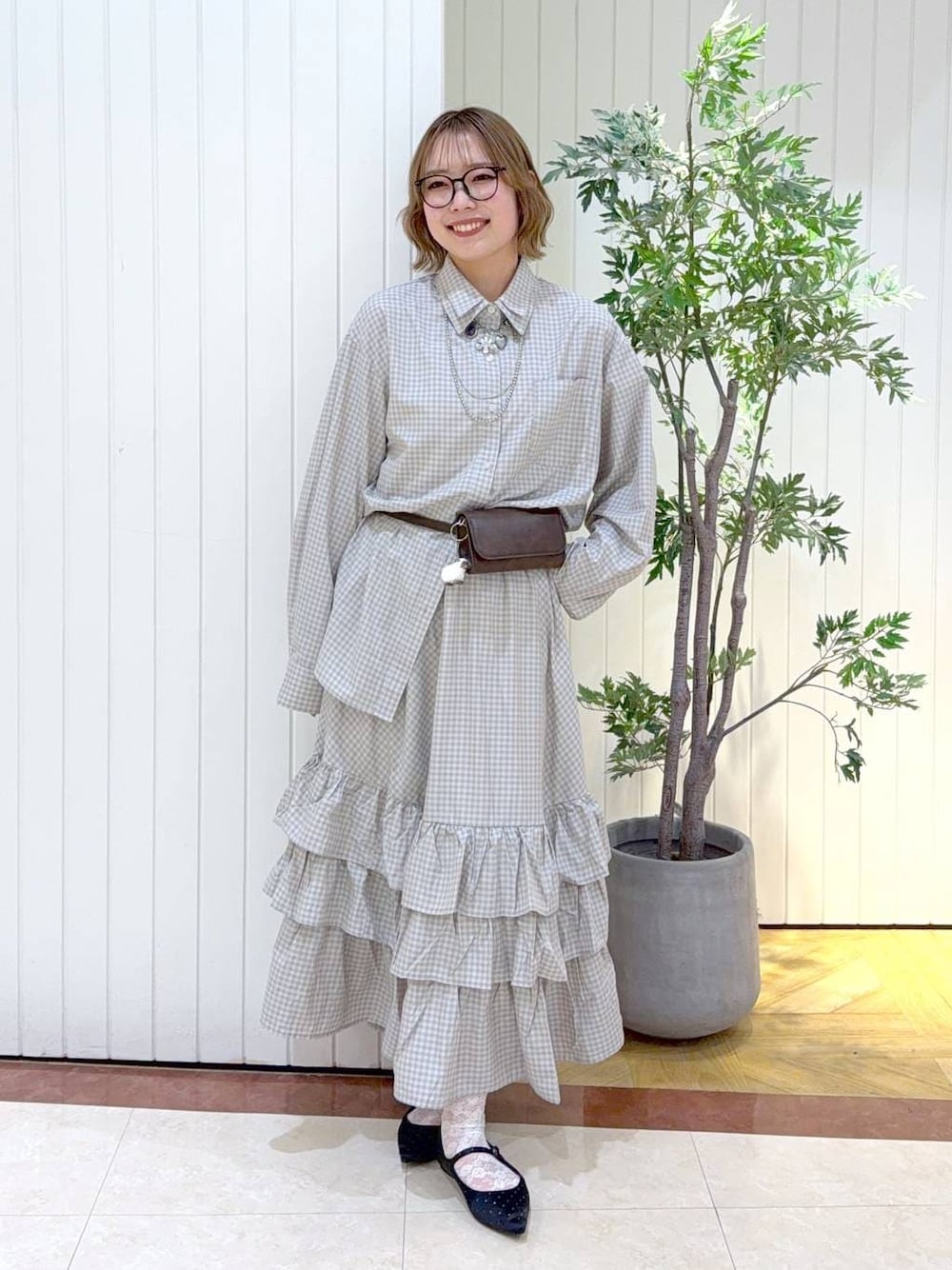 ブラック系のパンプス、ブルー系のシャツ/ブラウス、ブルー系のスカートを着用したレディースの春コーディネートの1枚目の写真