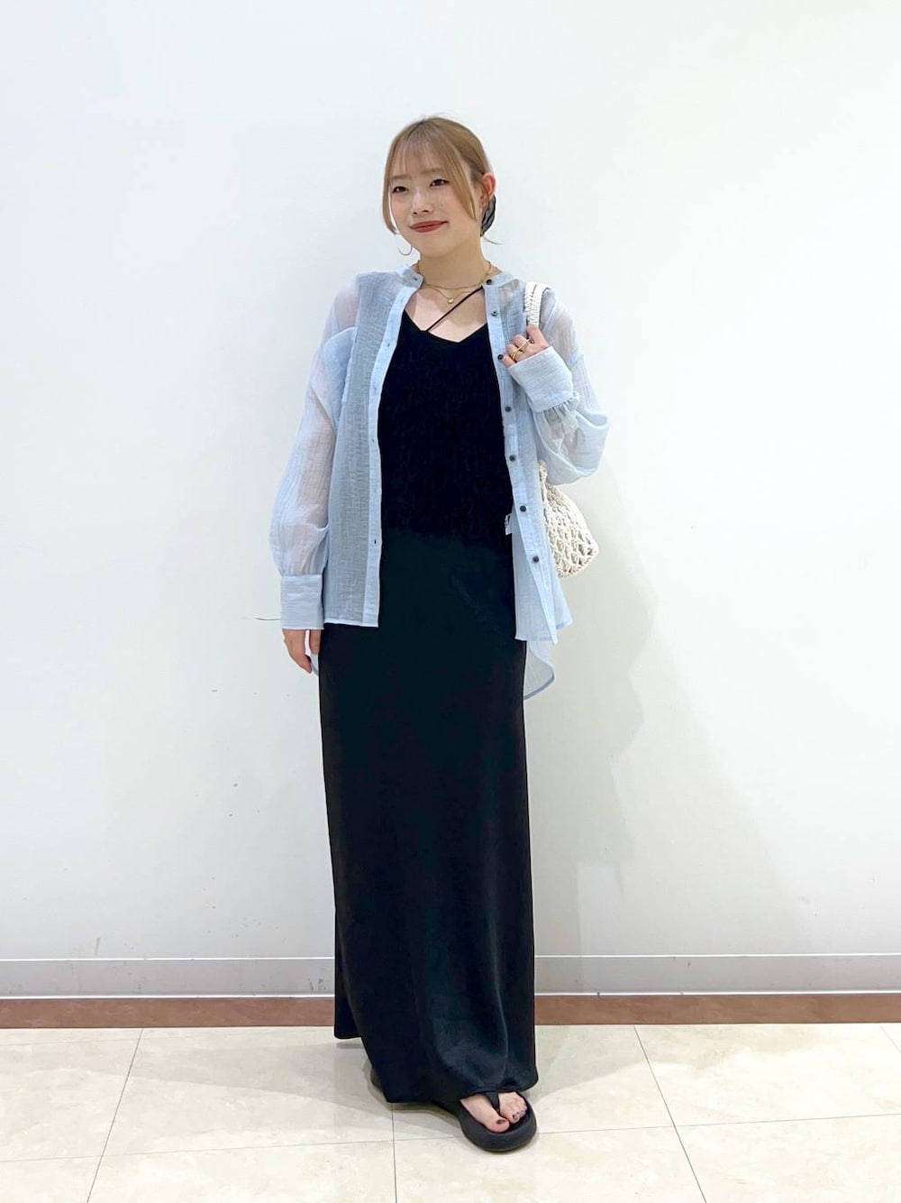 ブラック系のサンダル、ホワイト系のトートバッグ、ブラック系のキャミソールを着用したレディースの夏コーディネートの1枚目の写真