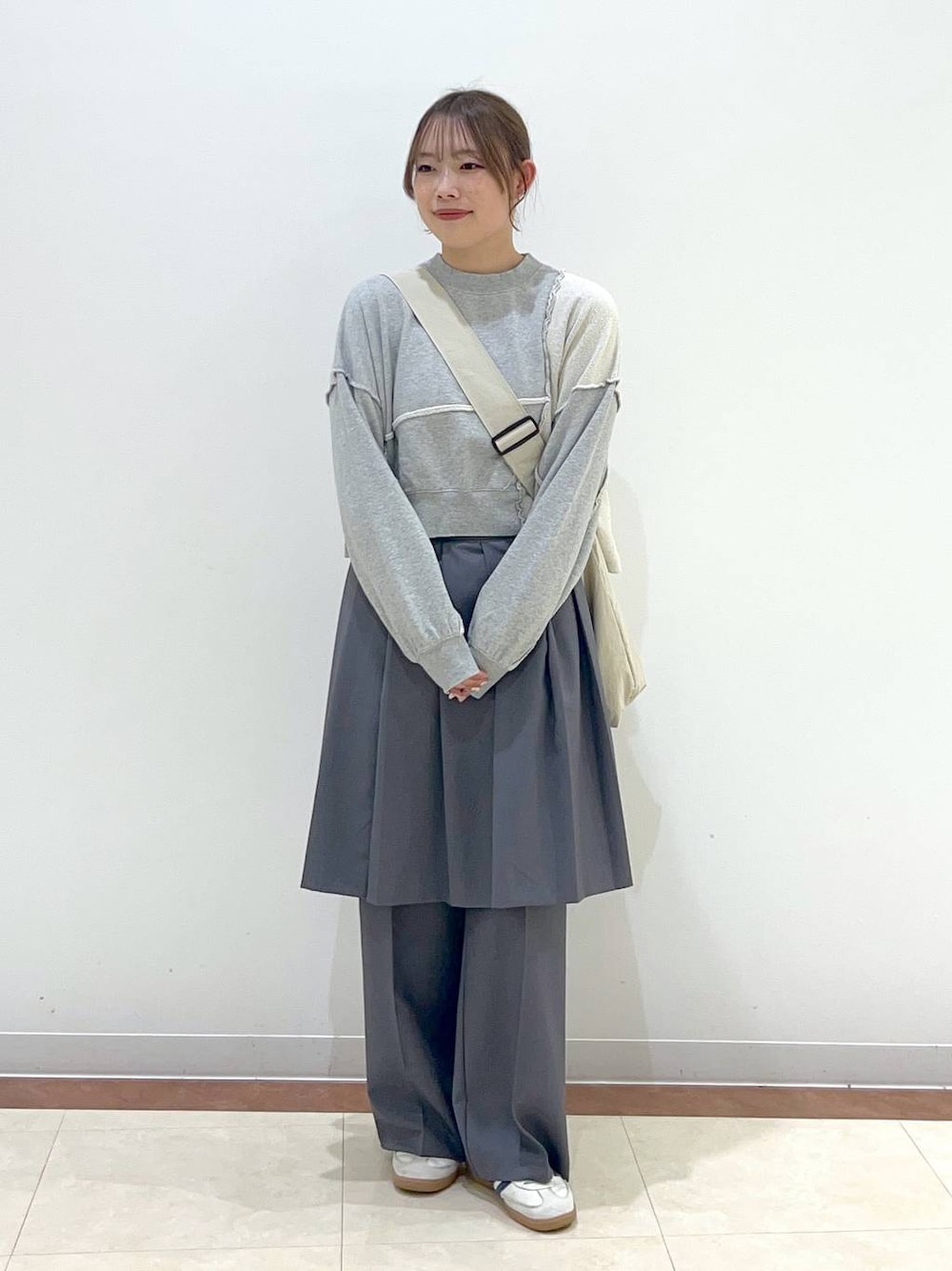 グレー系のスウェット、ベージュ系のショルダーバッグ、グレー系のその他パンツを着用したレディースの春コーディネートの1枚目の写真