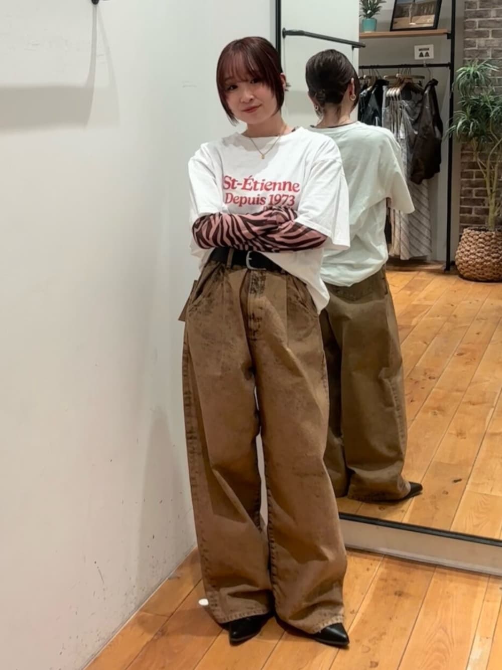 ホワイト系のTシャツ/カットソー、ブラック系のTシャツ/カットソー、ブラウン系のデニムパンツを着用したレディースの春コーディネートの1枚目の写真