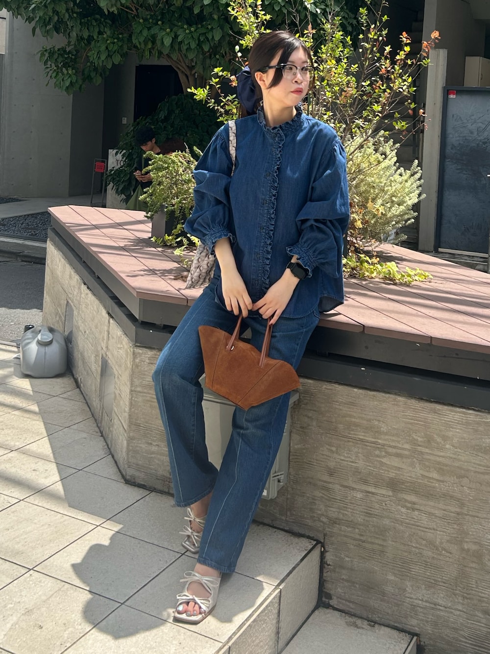 ブルー系のシャツ/ブラウス、ブルー系のデニムパンツ、パープル系のショルダーバッグを着用したレディースの夏コーディネートの1枚目の写真