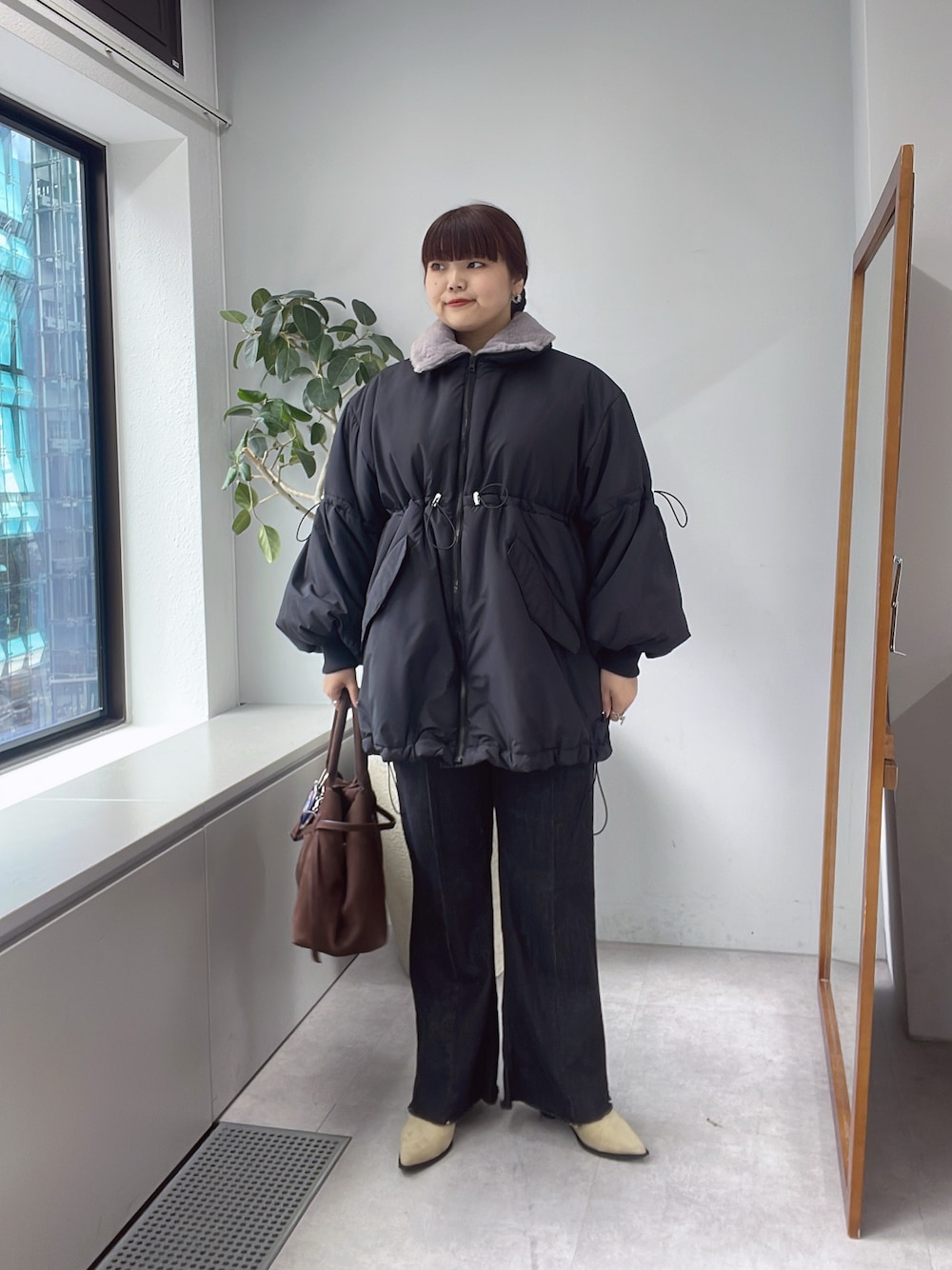 ブラック系のその他アウター、ブルー系のデニムパンツを着用したレディースの秋コーディネートの1枚目の写真