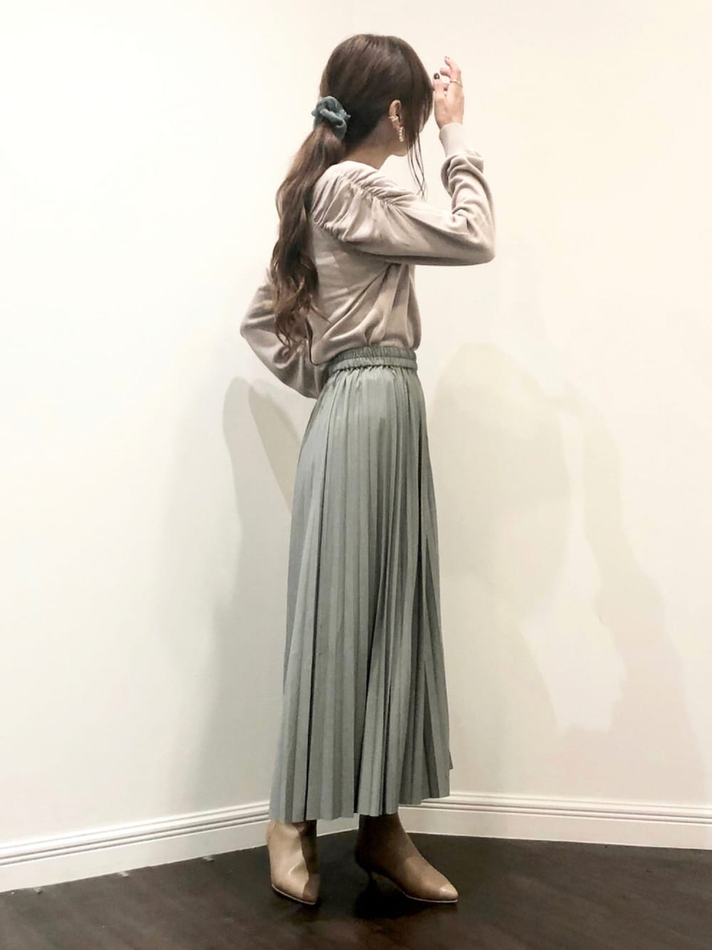 ベージュ系のニット/セーター、グリーン系のスカート、ベージュ系のブーツを着用したレディースの秋コーディネートの1枚目の写真