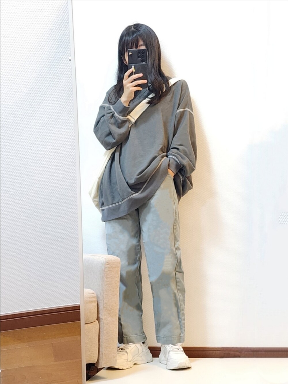 グレー系のTシャツ/カットソー、グリーン系のデニムパンツ、ホワイト系のスニーカーを着用したレディースの秋コーディネートの1枚目の写真