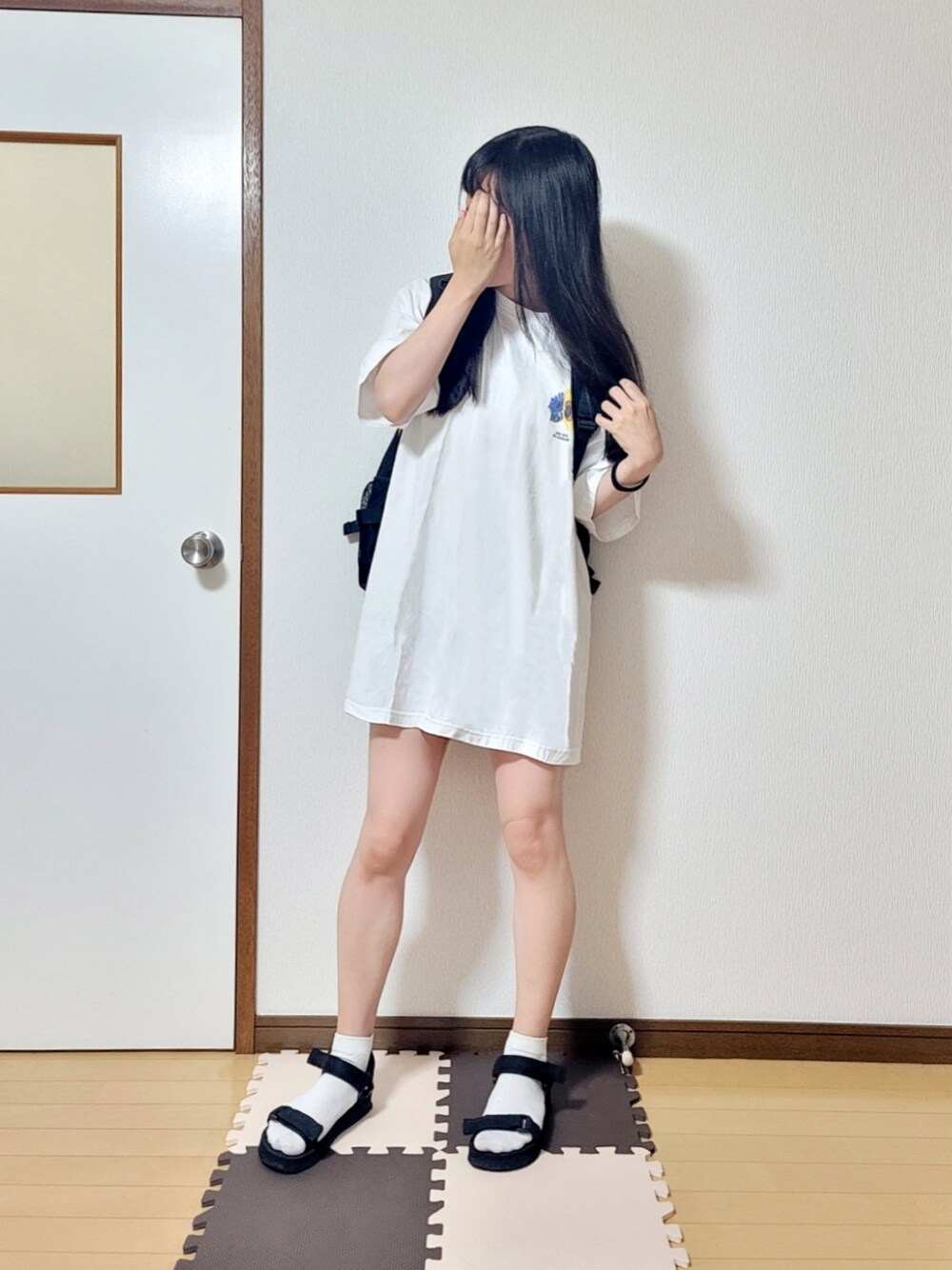 ホワイト系のTシャツ/カットソー、ブラック系のサンダル、ブラック系のバックパック/リュックを着用したレディースの夏コーディネートの1枚目の写真