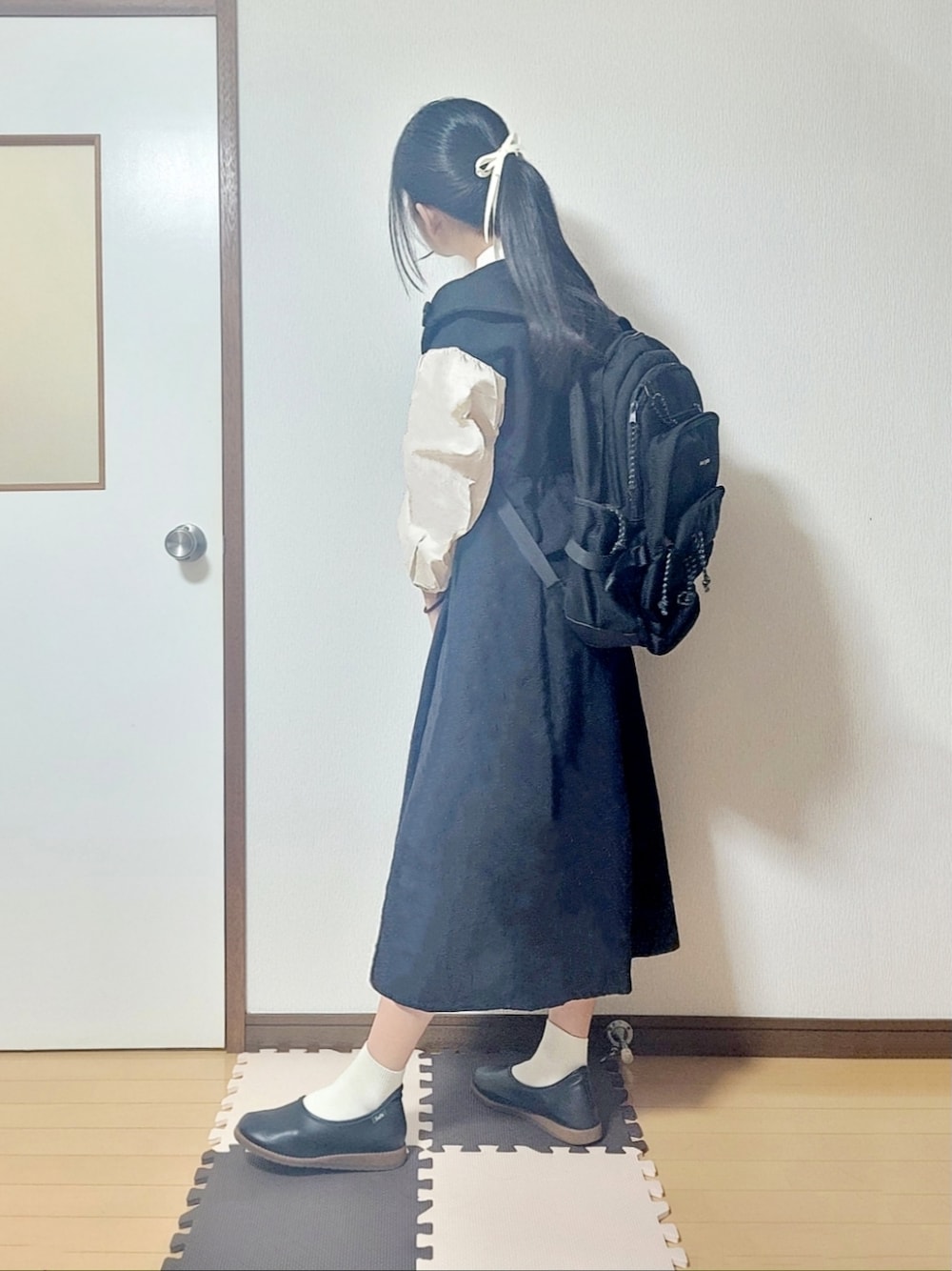 ブラック系のワンピース、ブラック系のバレエシューズ、ブラック系のバックパック/リュックを着用したレディースの夏コーディネートの1枚目の写真