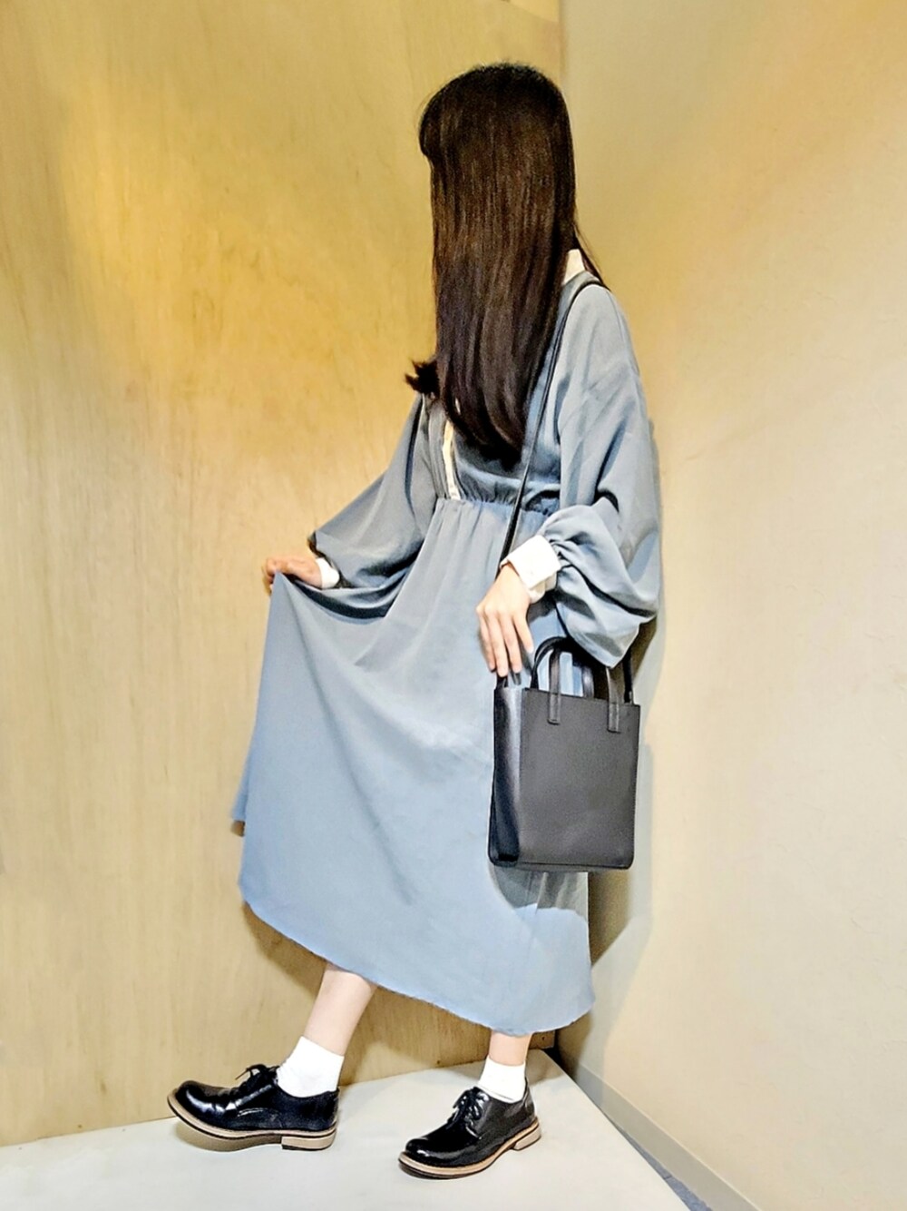 ブルー系のワンピース、ブラック系のトートバッグ、ブラック系のドレスシューズを着用したレディースの春コーディネートの1枚目の写真