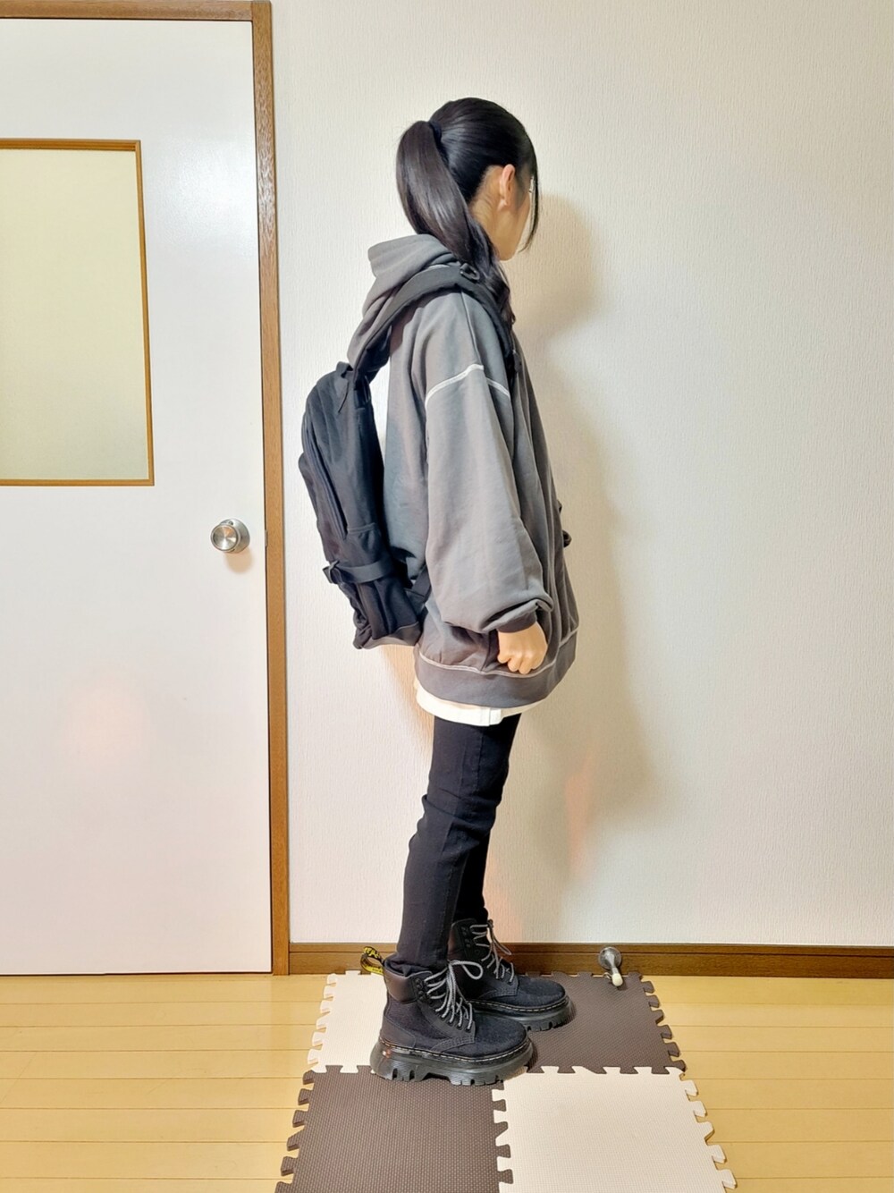 ブラック系のブルゾン、グレー系のTシャツ/カットソー、ホワイト系のTシャツ/カットソーを着用したレディースの冬コーディネートの2枚目の写真
