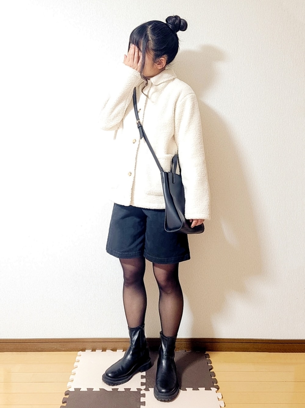 ホワイト系のその他アウター、ホワイト系のニット/セーター、ブラック系のトートバッグを着用したレディースの冬コーディネートの1枚目の写真
