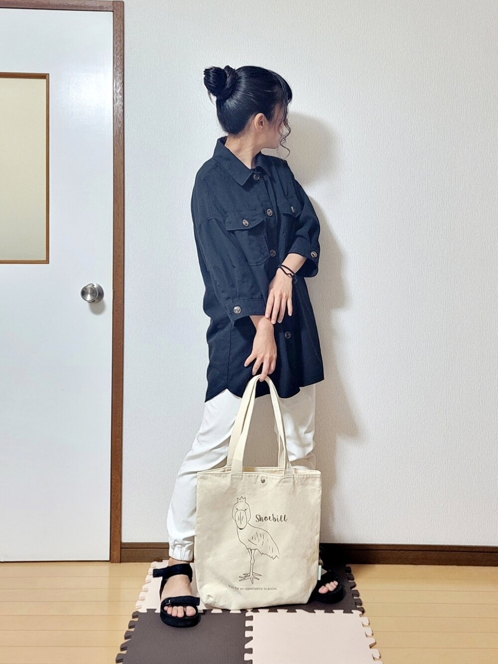 ブラック系のシャツ/ブラウス、ホワイト系のチノパンツ、ホワイト系のトートバッグを着用したレディースの夏コーディネートの1枚目の写真