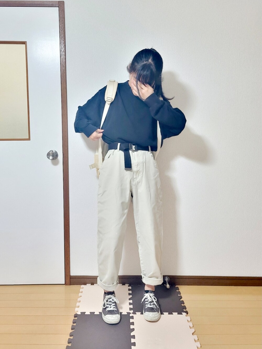 ブラック系のスウェット、ブルー系のステンカラーコート、ベージュ系のチノパンツを着用したレディースの冬コーディネートの2枚目の写真