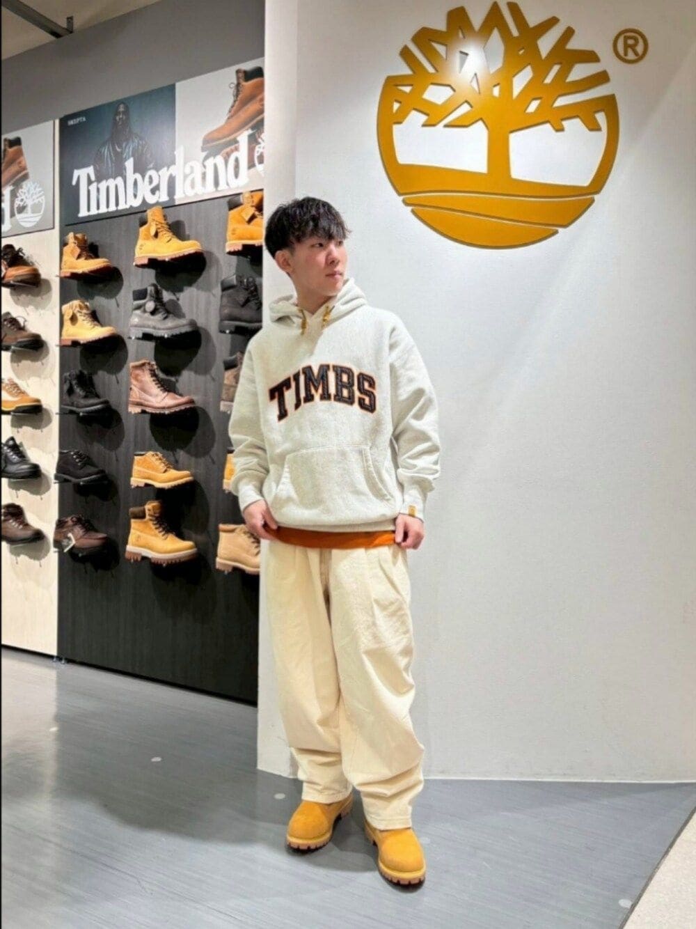 グレー系のパーカー、ベージュ系のブーツを着用したメンズの秋コーディネートの1枚目の写真