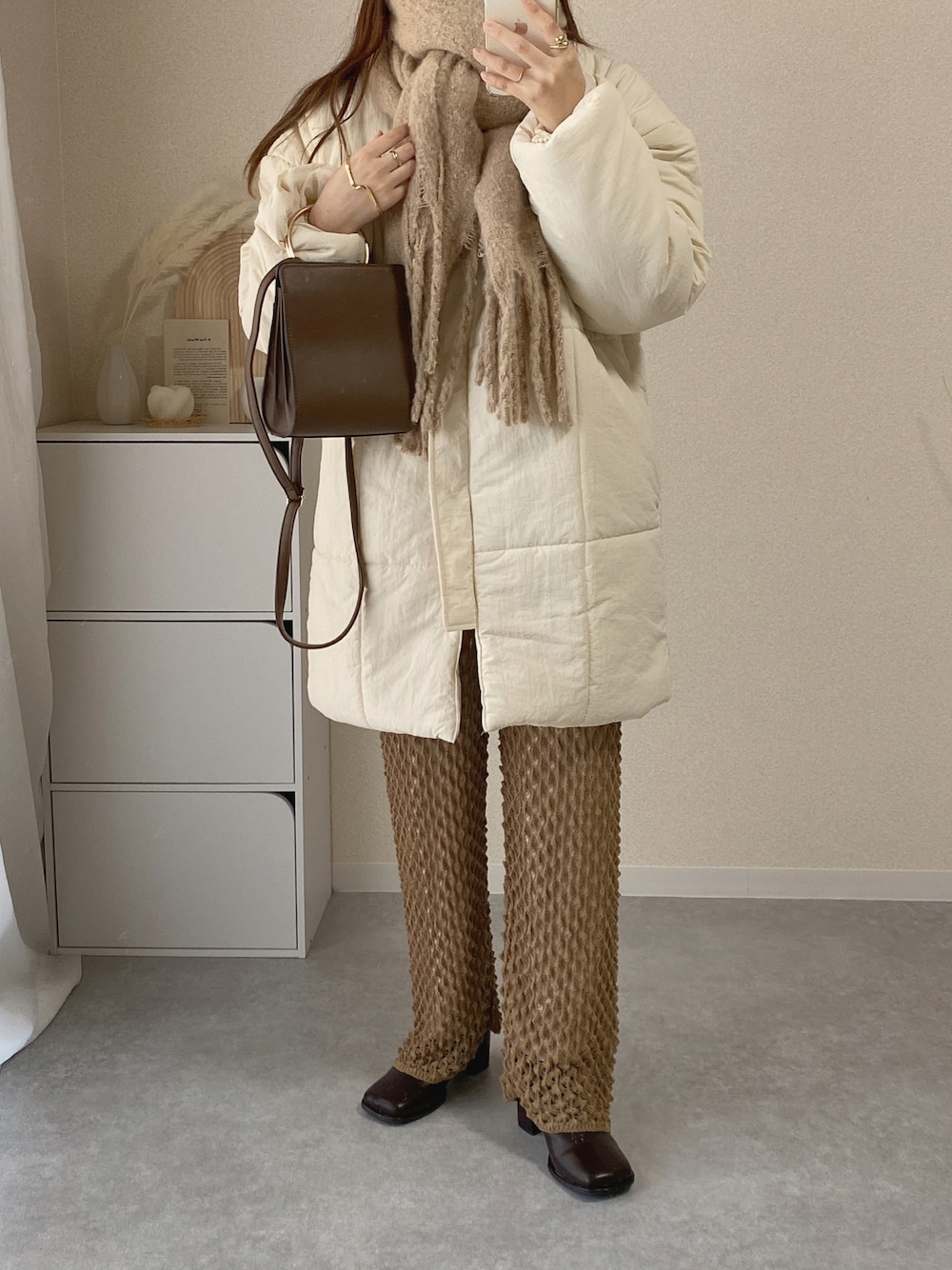 ホワイト系のダウンジャケット/コート、ブラウン系のショルダーバッグ、ブラウン系のその他パンツを着用したレディースの冬コーディネートの1枚目の写真