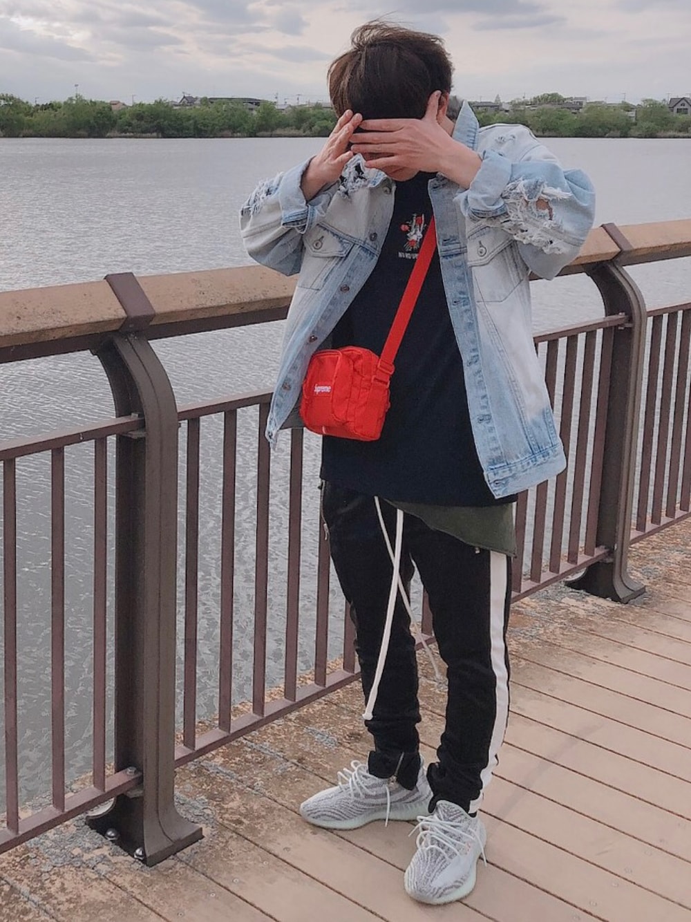 ブラック系のスウェットパンツ、グレー系のスニーカー、ブルー系のデニムジャケットを着用したメンズの冬コーディネートの1枚目の写真