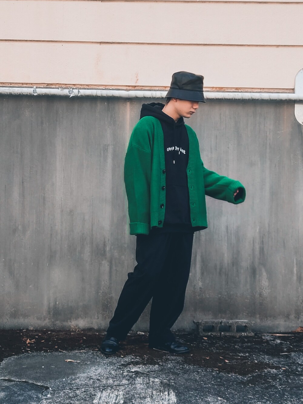 ブラック系のパーカー、グリーン系のカーディガン/ボレロ、ブラック系のスラックスを着用したメンズの冬コーディネートの2枚目の写真