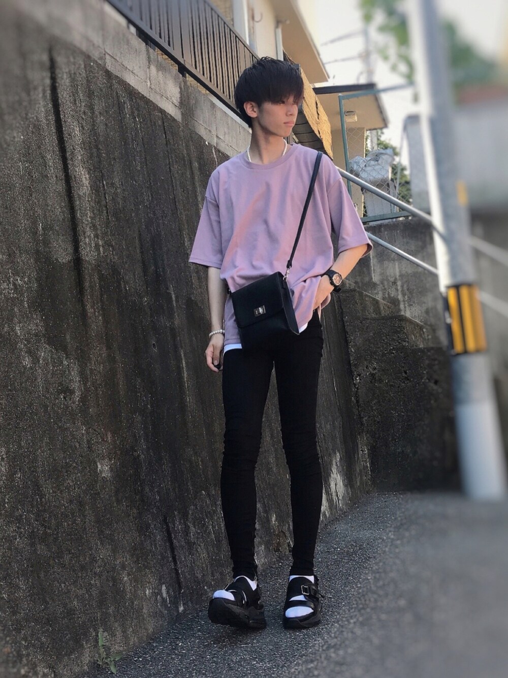 ピンク系のTシャツ/カットソー、ブラック系のショルダーバッグ、ブラック系のデニムパンツを着用したメンズの夏コーディネートの1枚目の写真