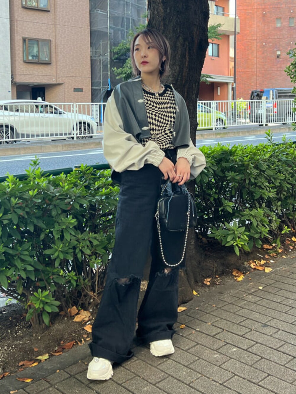 ブラック系のニット/セーター、ホワイト系のスニーカー、ブラック系のデニムパンツを着用したレディースの秋コーディネートの1枚目の写真