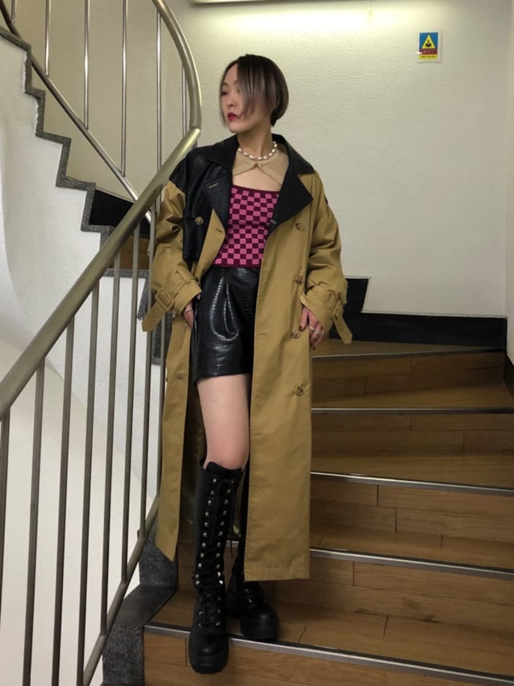 ベージュ系のトレンチコート、ブラック系のその他パンツ、ブラック系のブーツを着用したレディースの春コーディネートの1枚目の写真