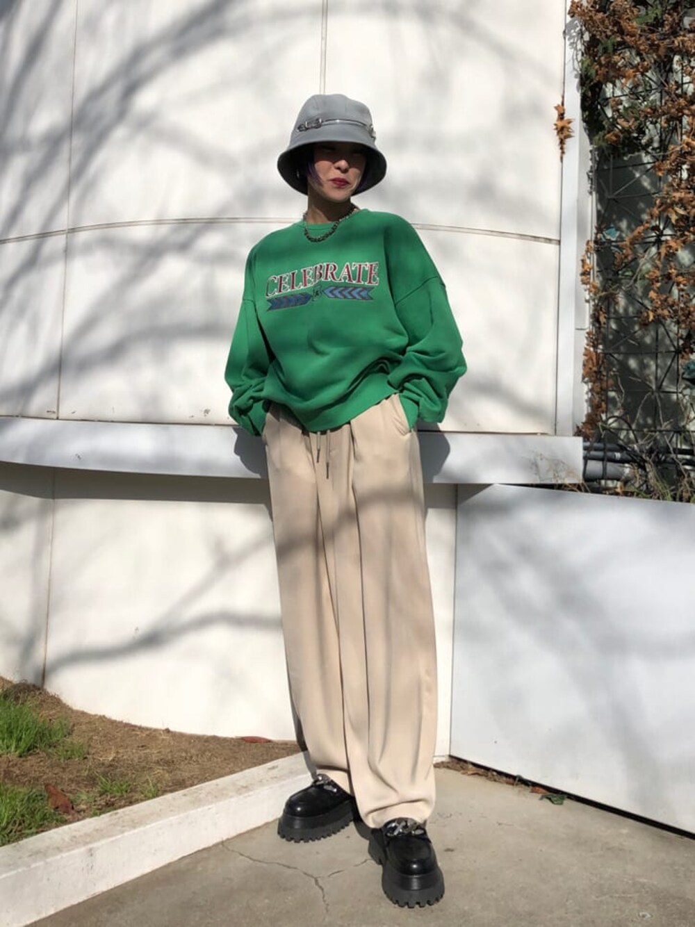 ホワイト系のスラックス、グリーン系のスウェットを着用したレディースの冬コーディネートの1枚目の写真