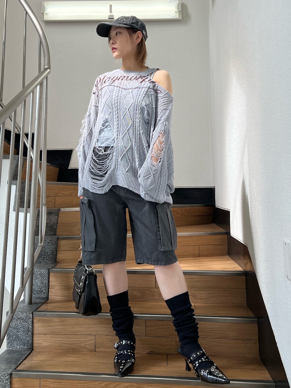 ブラック系のパンプス、ブラック系のカーゴパンツ、ブルー系のキャミソールを着用したレディースの春コーディネートの1枚目の写真