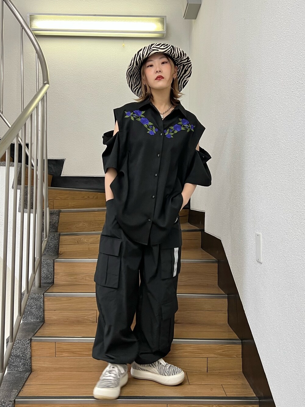 ブラック系のカーゴパンツ、ブラック系のシャツ/ブラウス、ホワイト系のハットを着用したレディースの春コーディネートの1枚目の写真