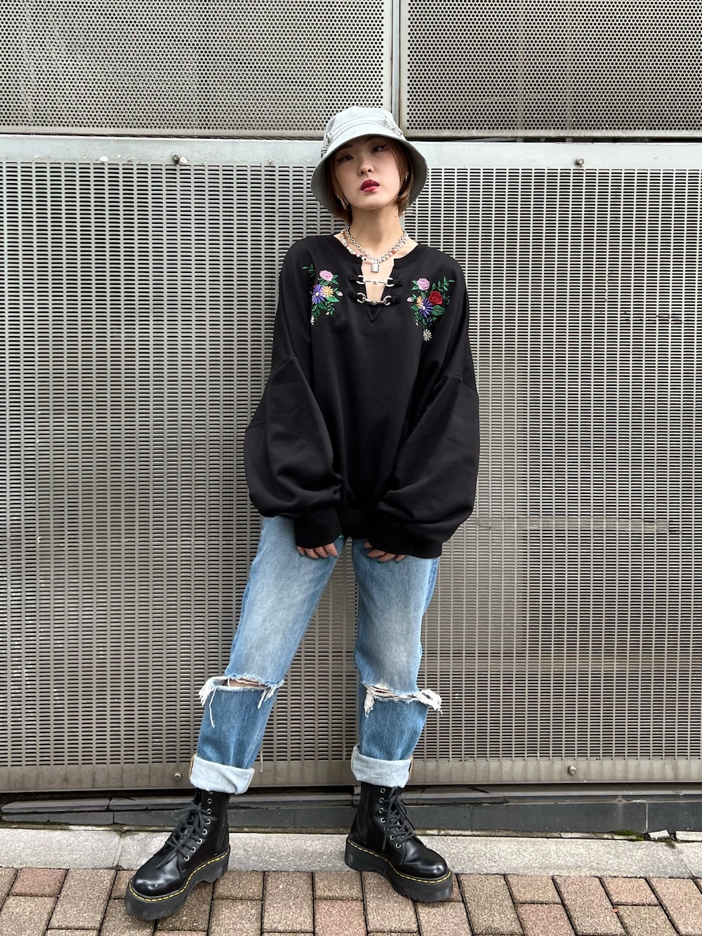 ブラック系のTシャツ/カットソー、ブルー系のデニムパンツ、ブラック系のブーツを着用したレディースの秋コーディネートの1枚目の写真