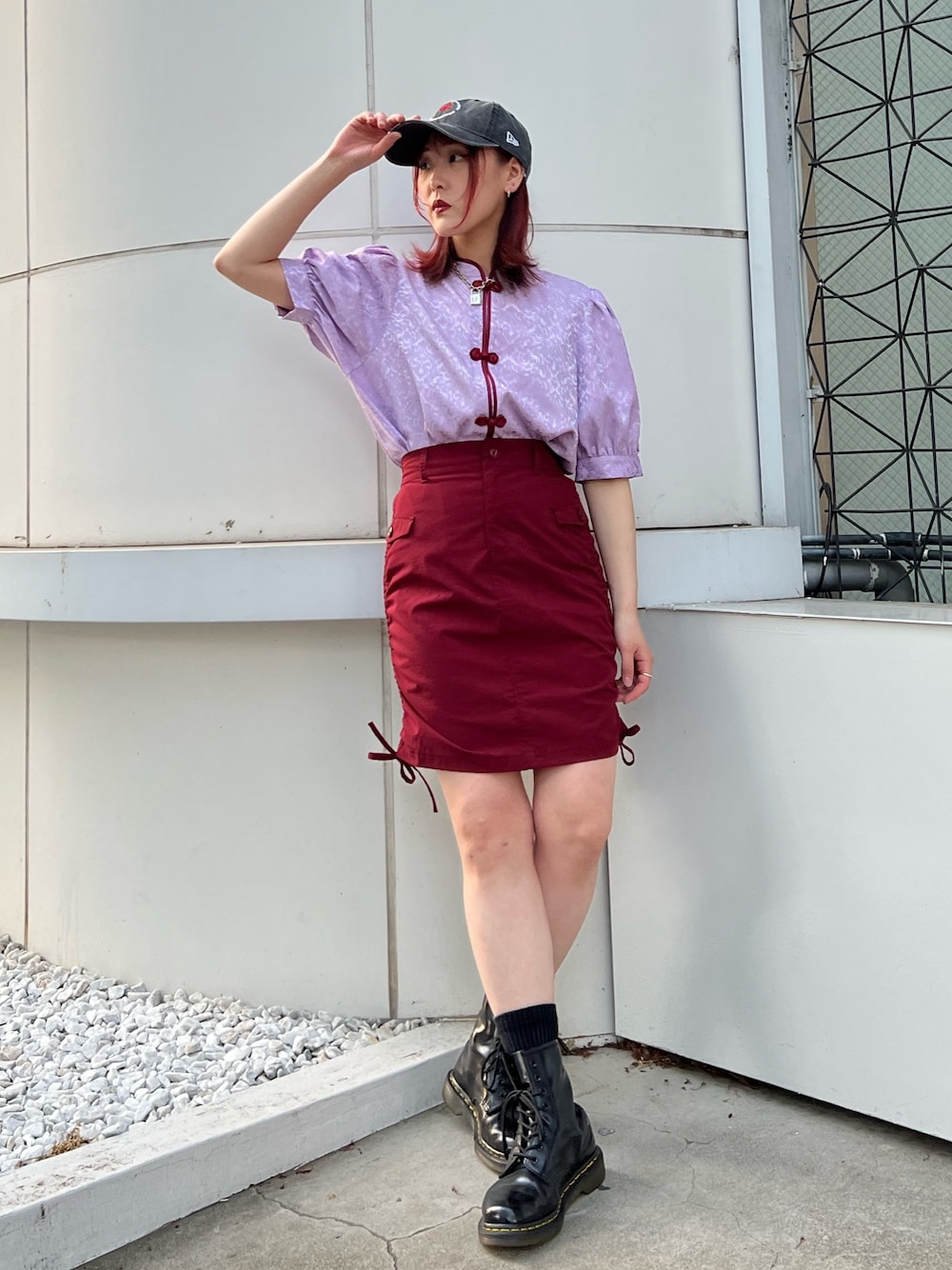 パープル系のシャツ/ブラウス、レッド系のスカート、ブラック系のキャップを着用したレディースの春コーディネートの1枚目の写真