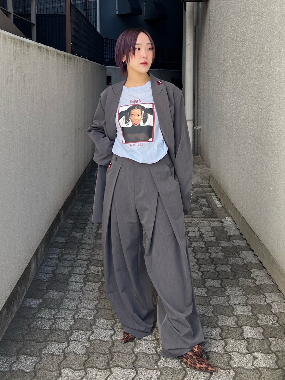 グレー系のテーラードジャケット、グレー系のスラックス、ブルー系のTシャツ/カットソーを着用したレディースの春コーディネートの1枚目の写真