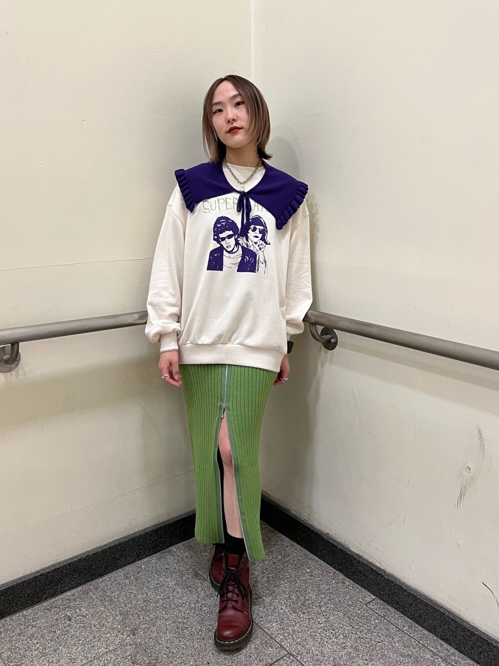 グリーン系のスカート、ホワイト系のニット/セーターを着用したレディースの冬コーディネートの1枚目の写真