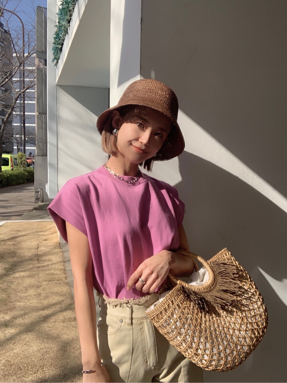 イエロー系のその他パンツ、ベージュ系のかごバッグ、ホワイト系のサンダルを着用したレディースの春コーディネートの1枚目の写真