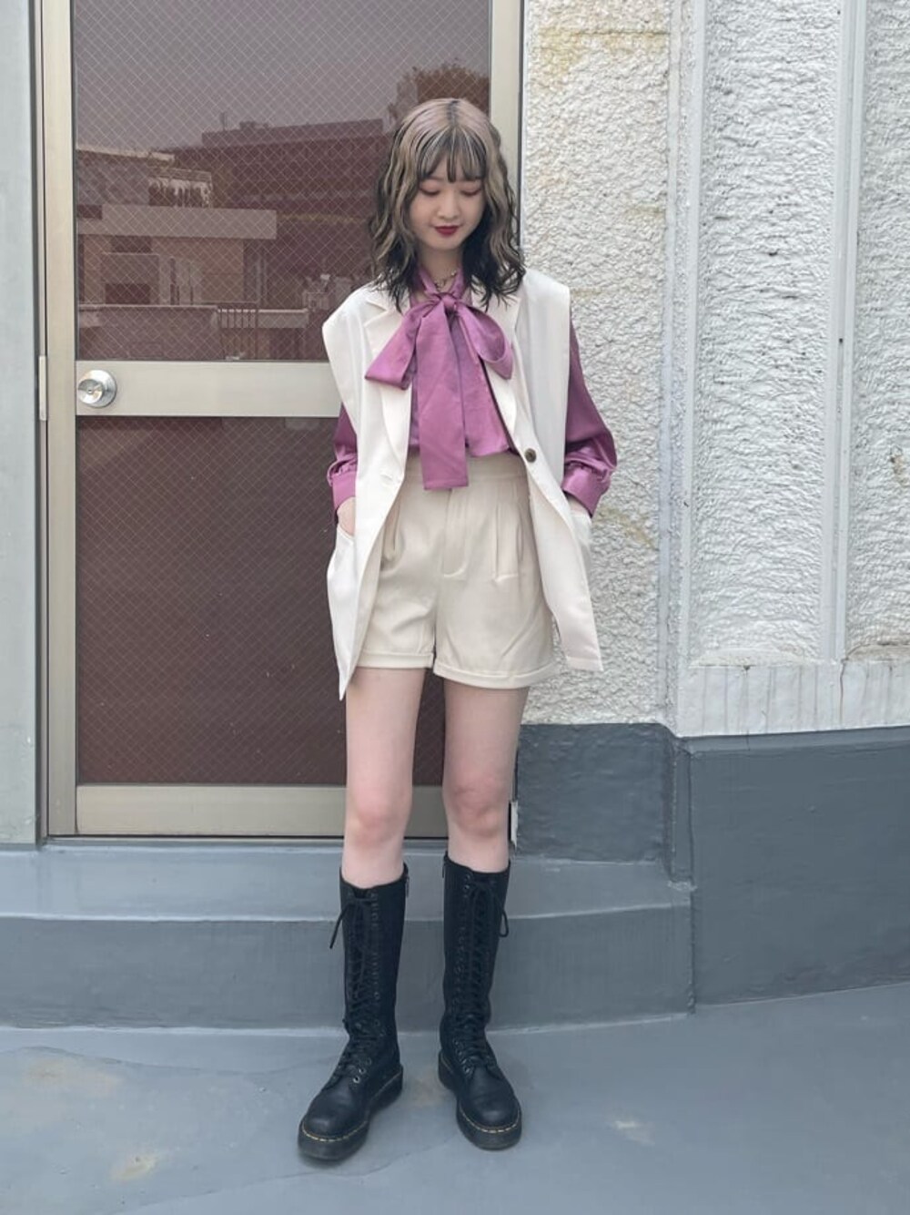 ピンク系のシャツ/ブラウス、ブラック系のブーツ、ホワイト系のベストを着用したレディースの春コーディネートの1枚目の写真