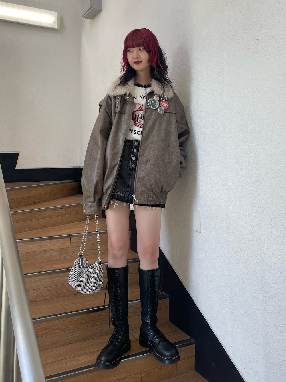 ブラック系のデニムパンツ、ブラウン系のブルゾン、ホワイト系のTシャツ/カットソーを着用したレディースの秋コーディネートの1枚目の写真