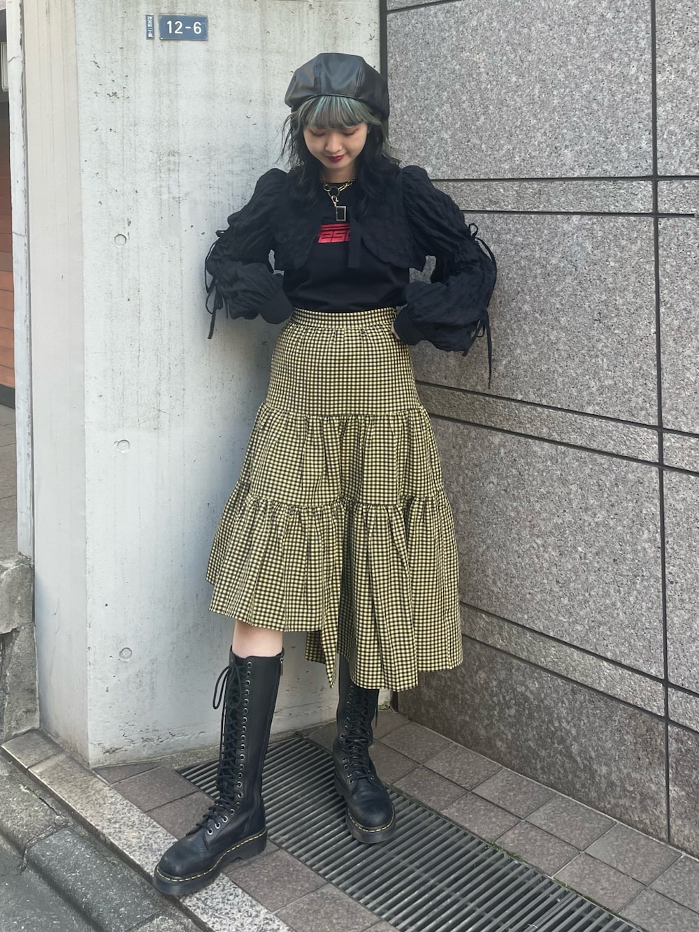 イエロー系のスカート、ブラック系のカーディガン/ボレロ、ブラック系のTシャツ/カットソーを着用したレディースの春コーディネートの1枚目の写真