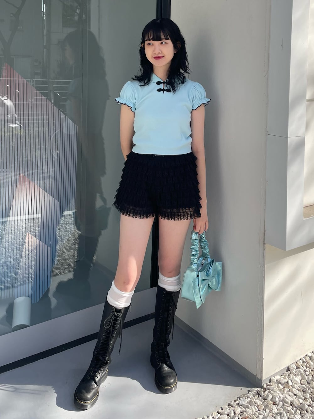 ブルー系のポロシャツ、ブラック系のその他パンツ、ブルー系のハンドバッグを着用したレディースの冬コーディネートの1枚目の写真