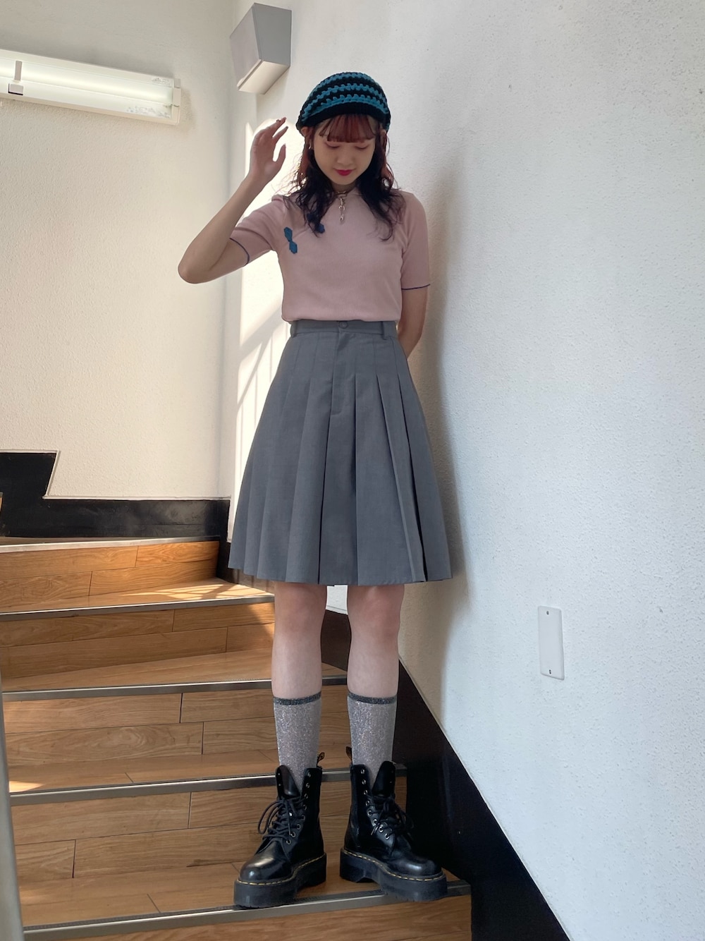 グレー系のスカート、ピンク系のポロシャツ、ブラック系のその他シューズを着用したレディースの春コーディネートの1枚目の写真