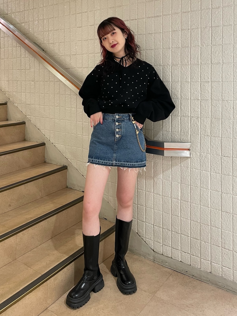 ブラック系のスウェット、ブルー系のデニムパンツ、ブラック系のブーツを着用したレディースの冬コーディネートの1枚目の写真