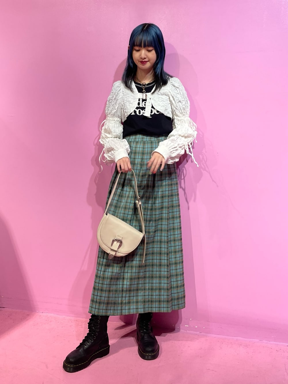 ブラック系のTシャツ/カットソー、ホワイト系のカーディガン/ボレロ、グリーン系のスカートを着用したレディースの冬コーディネートの1枚目の写真