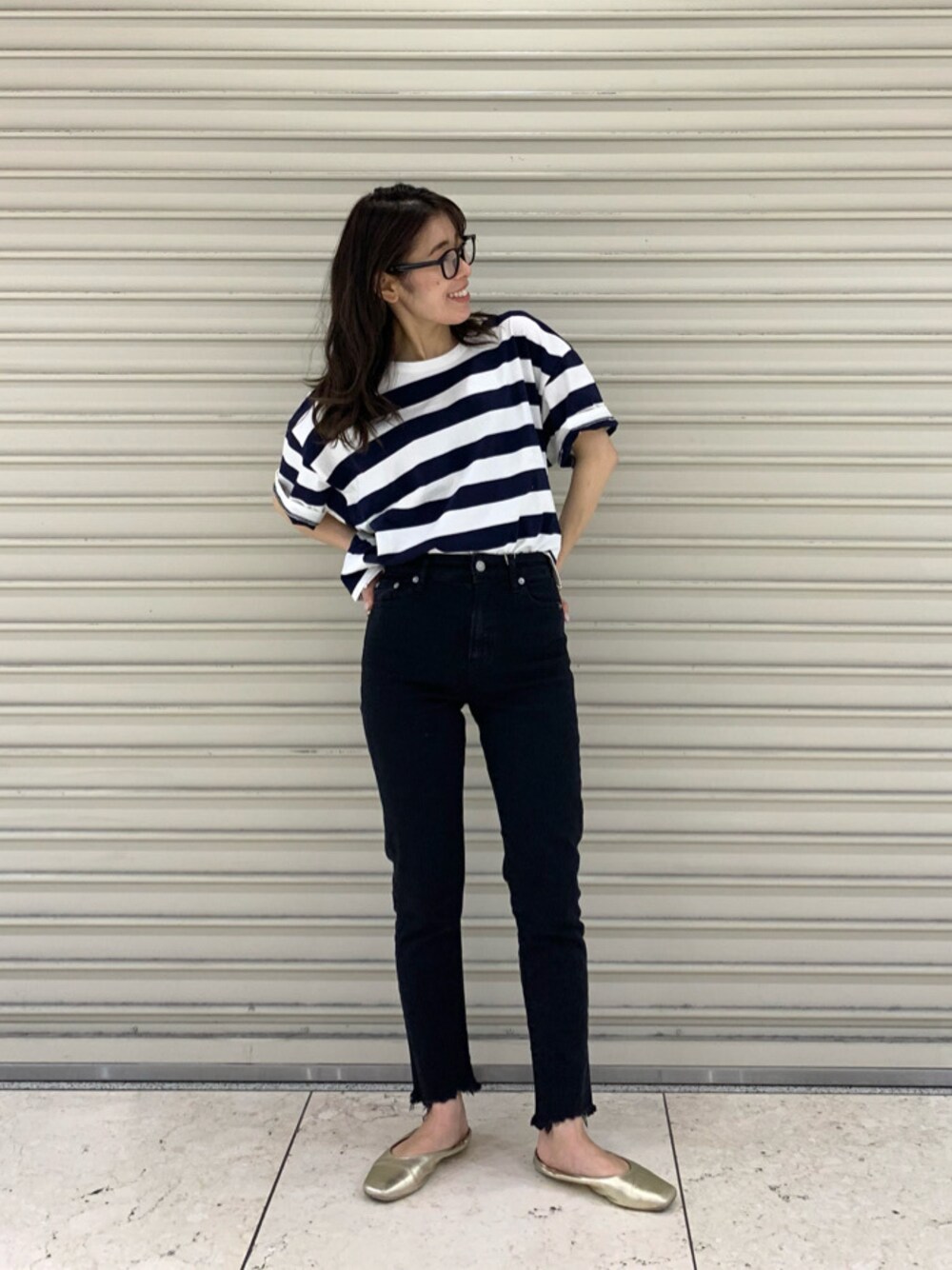 ブラック系のデニムパンツ、ブラック系のメガネを着用したレディースの春コーディネートの1枚目の写真