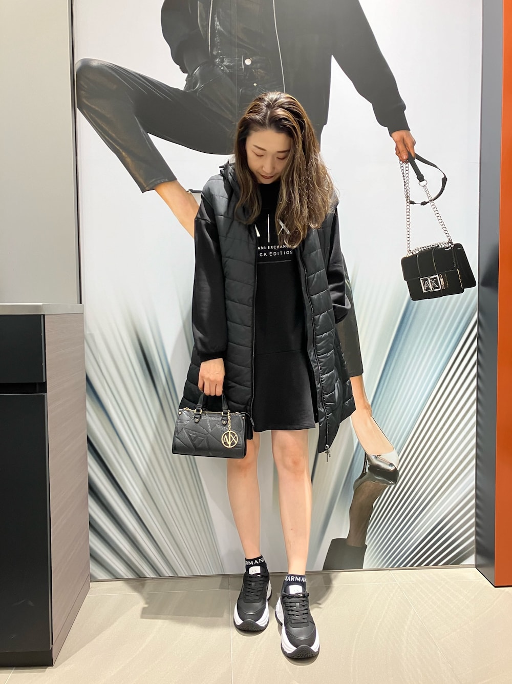 「AXchanger、AXchange、armaniexchange、ARMANIEXCHANGE、ARMANIworld、WelcomeARMANI、アルマーニエクスチェンジ、高身長女子、ワンピース、ダウンベスト、ブラック、オールブラック、スニーカー、ミニバッグ、ロゴ」｜「ARMANI EXCHANGEの【A|X アルマーニ エクスチェンジ】ADE バルーンスリーブスウェットワンピース（EC限定カラー含）（ワンピース、ブラック系）」を使った、Iku.Yさん（レディース・168cm）の冬コーディネートの1枚目の写真