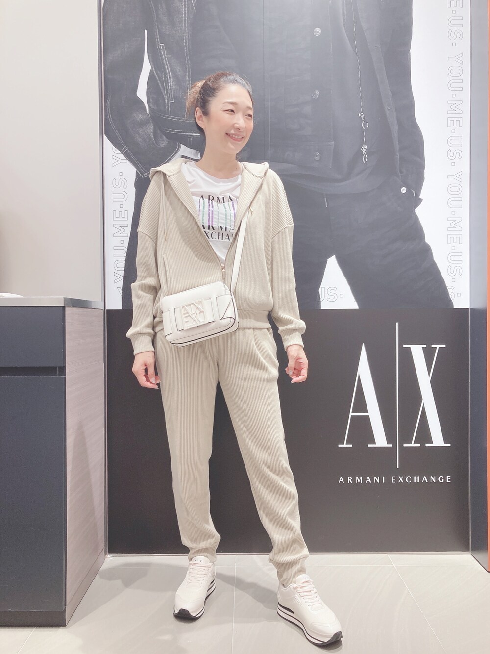 ホワイト系のショルダーバッグ、ベージュ系のスウェットパンツ、ホワイト系のTシャツ/カットソーを着用したレディースの夏コーディネートの1枚目の写真