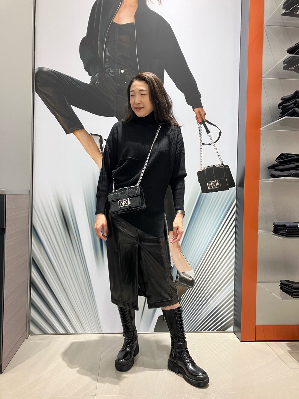 「AXchanger、AXchange、armaniexchange、ARMANIEXCHANGE、ARMANIworld、WelcomeARMANI、アルマーニエクスチェンジ、高身長女子、オールブラック、モノトーン、スカート、ハイネック、ショルダーバッグ、ニット、ロングブーツ」｜「ARMANI EXCHANGEの【A|X アルマーニ エクスチェンジ】AXロゴ　レースアップミディアムブーツ（ブーツ、ブラック系）」を使った、Iku.Yさん（レディース・168cm）の冬コーディネートの1枚目の写真