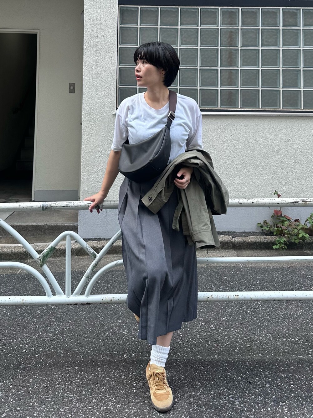 ブラウン系のショルダーバッグを着用したレディースの夏コーディネートの1枚目の写真