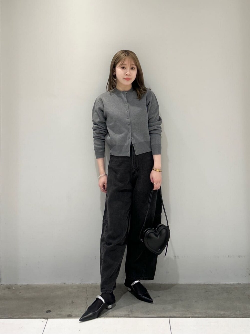 グレー系のカーディガン/ボレロ、ブラック系のデニムパンツ、ブラック系のサンダルを着用したレディースの春コーディネートの1枚目の写真