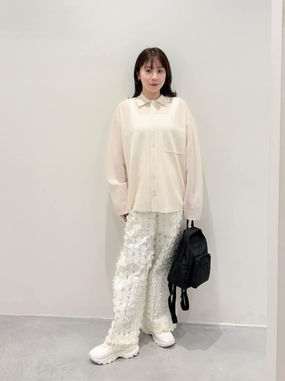ホワイト系のTシャツ/カットソー、ブラック系のバックパック/リュック、ホワイト系のカーディガン/ボレロを着用したレディースの春コーディネートの1枚目の写真
