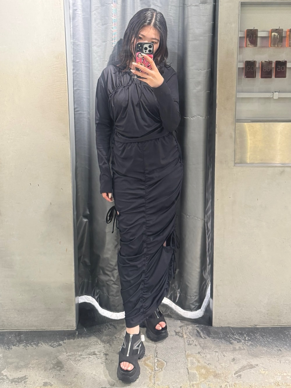 ブラック系のTシャツ/カットソー、ブラック系のスカート、ブラック系のサンダルを着用したレディースの春コーディネートの1枚目の写真