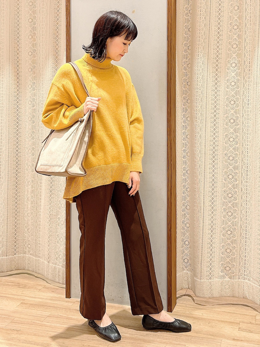 ブラック系のパンプス、ベージュ系のトートバッグ、ブラウン系のその他パンツを着用したレディースの冬コーディネートの1枚目の写真